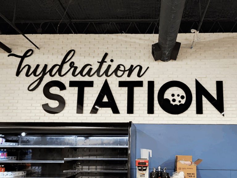 Black letters on a white brick wall spell 