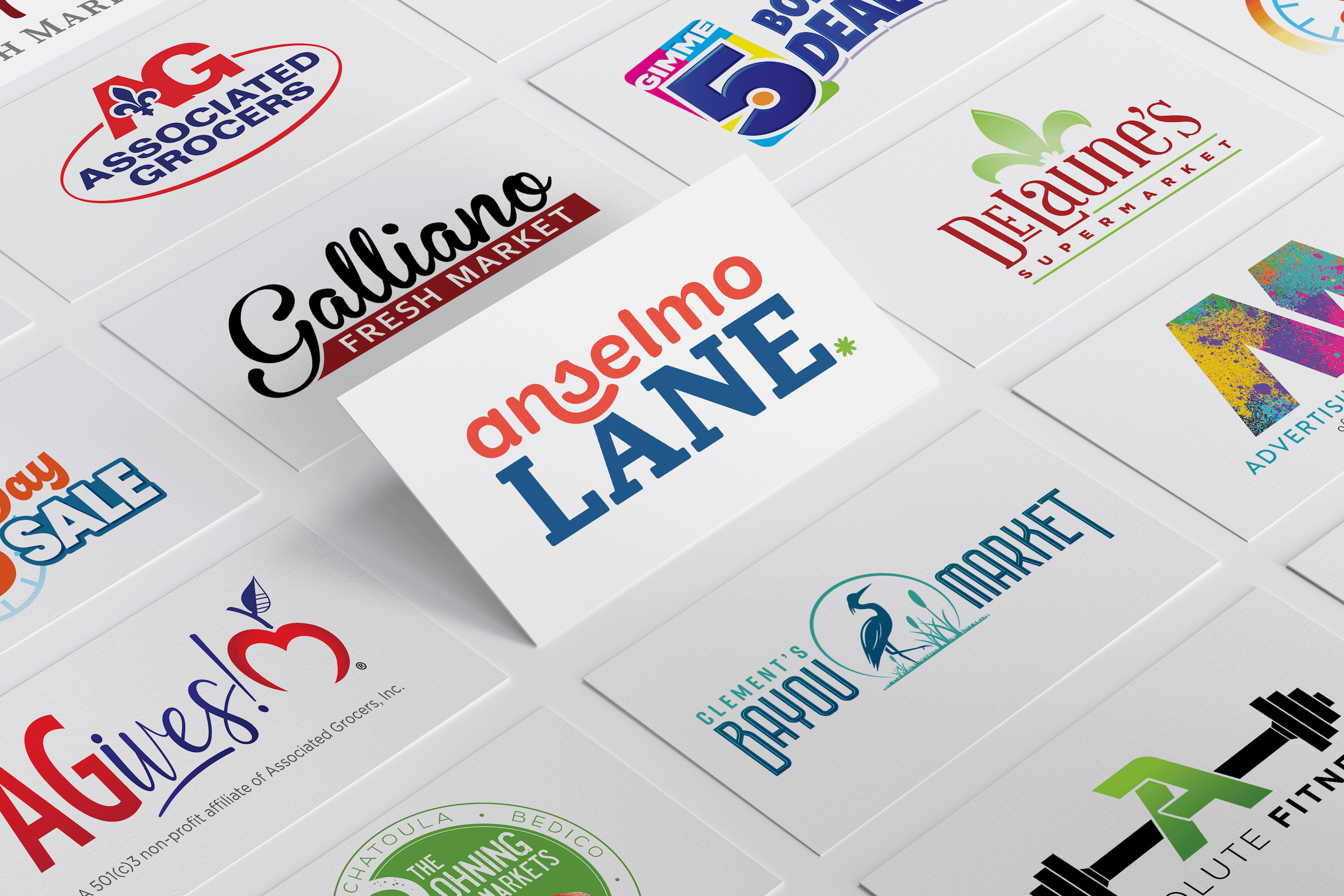 A group of business cards displays various fresh market and supermarket logos on a white surface.
